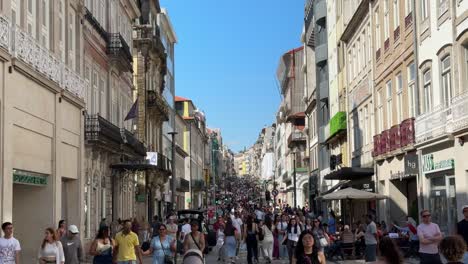 Tourists-walk-at-the-pedestrian-street-of-Rua-Santa-Catarina,-featuring-some-of-the-best-shopping-and-culinary-areas-in-the-whole-city,-during-the-celebration-of-the-São-João-do-Porto,-Portugal