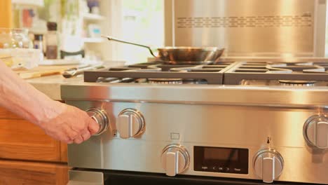 Stock-footage-of-a-close-up-shot-of-an-adult-woman-turning-on-the-stove-in-a-modern-kitchen