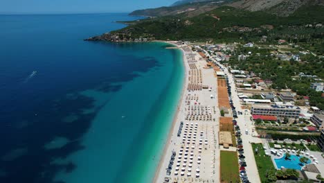 Large-White-Sand-Beach-of-Livadh,-Blue-Ionian-Sea-on-the-Albanian-Coast,-a-Popular-Destination-for-Summer-Holidays