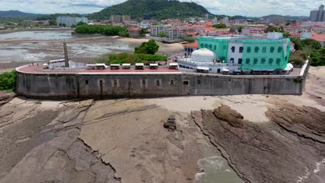 Toma-Aérea-Del-Casco-Antiguo-De-Panamá-Con-El-Cerro-Ancón-Y-La-Ciudad-De-Panamá-Al-Fondo.