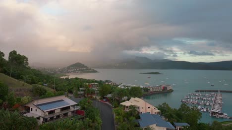 Puerto-Airlie-Playa-Bahía-Laguna-Coral-Mar-Puerto-Pequeño-Aéreo-Drone-Coches-De-Carretera-Hacia-Cannonvale-Rosas-Amarillas-Amaneceres-Mañana-Lluvia-Corazón-De-La-Gran-Barrera-De-Coral-Whitsundays-Whitehaven-Vecindario-Movimiento-Hacia-Adelante