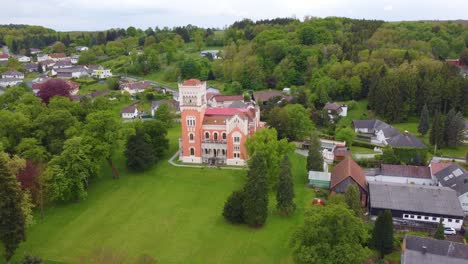 Rotenturm-Castle-lawn-looks-out-over-Burgenland-Austria,-drone-pan-estabilsh