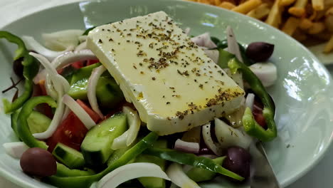 Foto-Detallada-De-Una-Ensalada-Verde,-Roja-Y-Blanca-Con-Queso-Y-Papas-Fritas