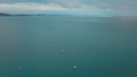 Sailboat-Yachts-of-Port-Airlie-Beach-Bay-Lagoon-Coral-Sea-marina-aerial-drone-Cannonvale-pink-yellow-sunrise-morning-heart-of-Great-Barrier-Reef-Whitsundays-Whitehaven-forward-down-motion