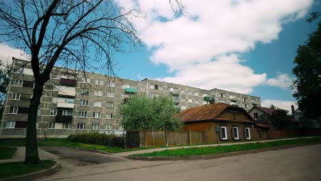 Footage-of-a-Baltic-traditional-wooden-house-situated-in-front-of-a-Soviet-concrete-layered-apartment-building