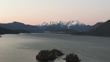 Sunrise-Over-Nimpkish-Lake:-Snow-Covered-Peaks-and-Serenity