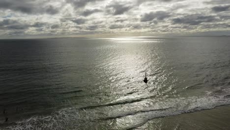 Aerial-descending-Cottesloe-Beach-and-Bell-on-overcast-day,-Perth,-Western-Australia