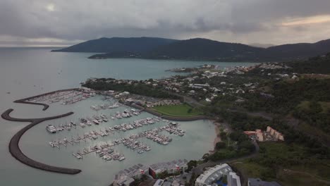 Hafen-Airlie-Beach-Bucht-Lagune-Korallenmeer-Yachthafen-Luftdrohne-Dunkle-Regenwolken-Nebel-Sonnenaufgang-Morgen-Herz-Des-Great-Barrier-Reef-Whitsundays-Whitehaven-Anlegestelle-Yachten-Segelboote-Gebäude-Kreis-Linksbewegung