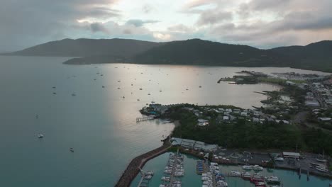 Port-Airlie-Beach-Bay-Lagoon-Coral-Sea-marina-aerial-drone-mist-sunrise-morning-rain-clouds-heart-of-Great-Barrier-Reef-Whitsundays-Whitehaven-jetty-yachts-sailboats-circle-right-motion