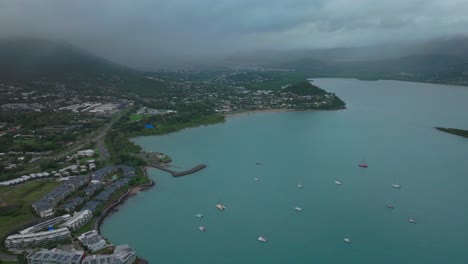 Rainy-Port-Airlie-Beach-Bay-Lagoon-Coral-Sea-marina-aerial-drone-road-cars-towards-Cannonvale-pink-yellow-sunrise-morning-heart-of-Great-Barrier-Reef-Whitsundays-Whitehaven-boats-backwards