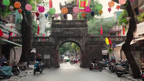 Colorful-footage-of-the-bustling-Ô-Quan-Chưởng-gate-in-Hanoi-Old-Town,-Vietnam,-decorated-with-lanterns-and-bustling-with-activity