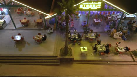 Top-view-aerial-shot-of-people-having-dinner-in-restaurants-in-the-vibrant-nightlife-of-Boten,-Laos