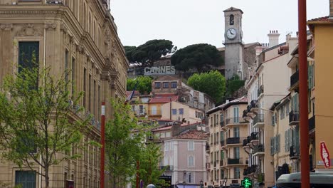 Kirchturm-Und-Cannes-Schild-Auf-Einem-Hügel-In-Frankreich,-Statische-Aufnahme-Aus-Niedrigem-Winkel