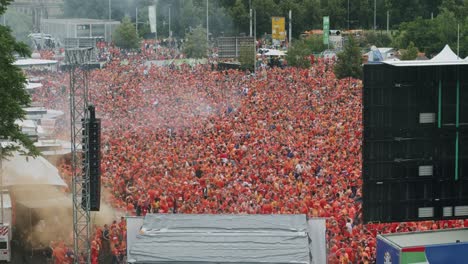 Huge-crowd-of-Dutch-soccer-fans-in-orange-celebrating-at-fan-zone-in-Leipzig,-Germany