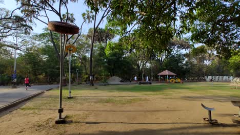 Toma-Fija-De-Una-Lámpara-De-Diseño-único-En-Un-Jardín,-Con-Gente-Caminando-En-Sayaji-Baugh,-Vadodara.