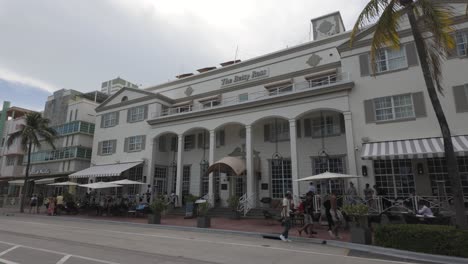 Charmante-Straße-In-Miami-Beach-Mit-Historischen-Art-Deco-Gebäuden,-Straßencafés-Und-Palmen-Entlang-Eines-Belebten-Bürgersteigs-Unter-Einem-Strahlenden-Himmel