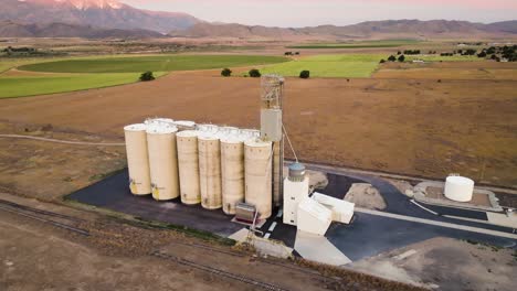 Grain-silo-elevator-in-a-farming-community-and-valley-in-Utah---aerial-parallax