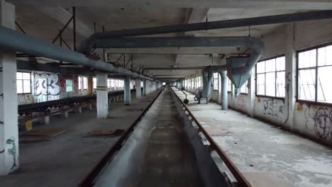 Inside-Abandoned-factory-building-with-conveyor-belt,-Gimbal-Dolly-Shot