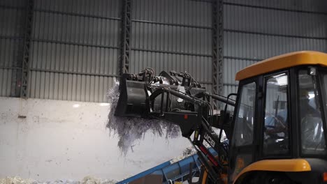 Throwing-the-wasteage-waste-inside-the-recycle-machine-with-JCB