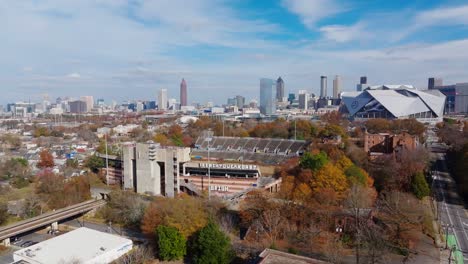 Drone-shot-of-abandoned-Alonzo-Herndon-stadium,-Mercedes-Benz-Stadium-with-the-view-of-Downtown-Atlanta-skyscrapers-in-autumn-season