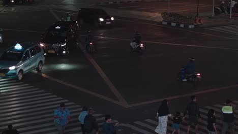 Footage-capturing-the-hustle-and-bustle-of-a-busy-intersection-in-Jakarta-City,-Indonesia,-during-nighttime