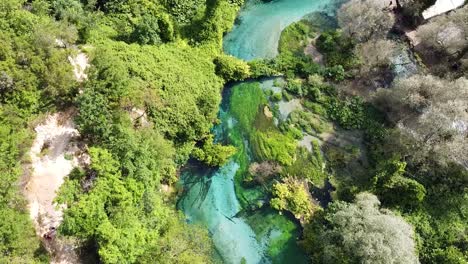 Drone-footage-of-The-Blue-Eye-in-Albania,-capturing-the-vibrant-blue-waters-and-lush-green-surroundings-from-above