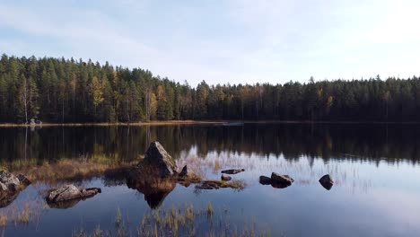 Drohnenaufnahmen-Eines-Ruhigen-Sees-In-Norwegen,-Die-Heitere-Spiegelungen-Der-Umliegenden-Herbstwälder-Und-Des-Klaren-Wassers-Einfangen