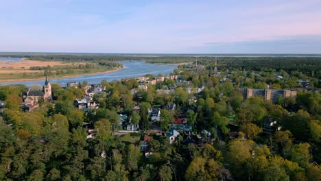 Vista-Panorámica-De-La-Zona-De-Pumpuri-De-Jurmala,-Que-Muestra-El-Río-Lielupe,-Las-Casas-Del-Pueblo-Y-El-Bosque-Circundante-Bajo-Un-Cielo-Despejado.