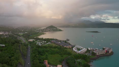 Port-Airlie-Beach-Bay-Lagoon-Coral-Sea-marina-aerial-drone-road-cars-towards-Cannonvale-pink-yellow-sunrise-morning-rain-heart-of-Great-Barrier-Reef-Whitsundays-Whitehaven-jetty-yachts-backward-motion