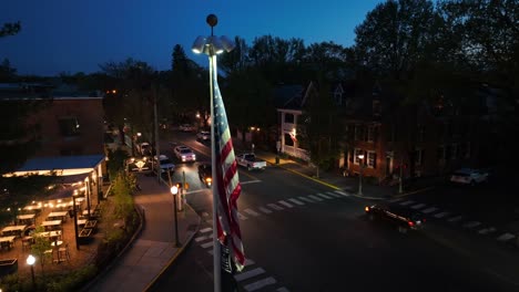 Bandera-De-Estados-Unidos-Iluminada-En-La-Calle-De-Una-Pequeña-Ciudad-Americana-Por-La-Noche