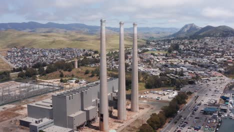 Aerial-close-up-panning-shot-of-the-famous-three-smokestacks-towering-above-the-abandoned-Morro-Bay-Power-Plant-in-Morro-Bay,-California