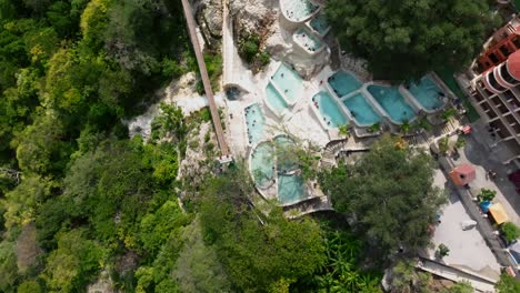 Aerial-flight-reveals-hot-springs-pools-at-Grutas-Tolantongo-resort,-Mexico