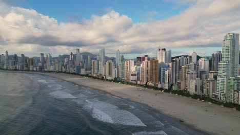 Reverse-Dolly-aerial-view-from-Central-Beach-and-it-oceanfront-skyscrapers-of-Balneario-Camboriu-during-morning-time---Santa-Catarina,-Brazil