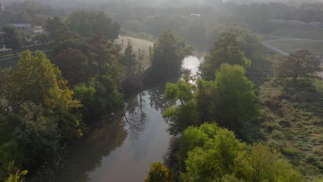 Bayou-Fluss-Mit-Sonnenreflexionen-Hinter-Bäumen-An-Einem-Nebligen-Morgen