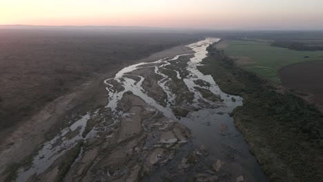 Shallow-seasonal-crocodile-river-reflects-early-morning-sunrise-light-in-braided-streams