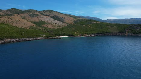 Tranquila-Playa-De-Arena-Blanca-Escondida-Entre-Verdes-Colinas-Y-Aguas-Azules-Del-Mar-Jónico-En-La-Costa-Albanesa