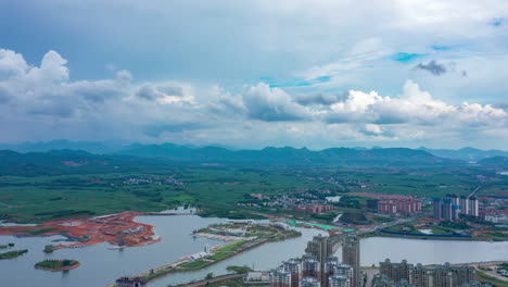 New-development-area-with-holiday-village-High-angle-overview-of-urban-outskirts-city-buildings-homes-near-lake-and-mountains-in-energy-saving-construction