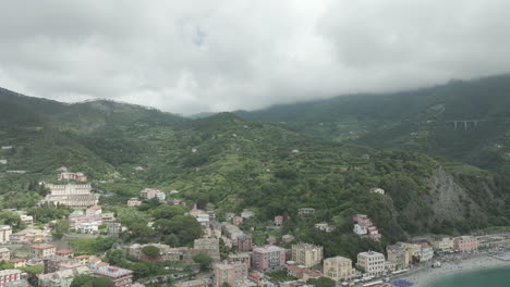 Wide-view-of-Monterosso-al-Mare-on-a-cloudy-day-and-showing-the-Liguria-Sea-in-Italy-with-the-drone-video-moving-in-a-circle