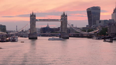 Ferry-passing-camera-with-sunset-view-of-Tower-Bridge-over-Thames-in-London