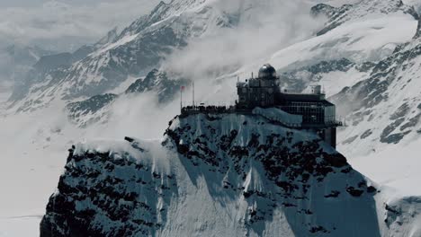 Descending-Pan-Up-of-Jungfraujoch-Station-Revealing-Snowy-Peaks