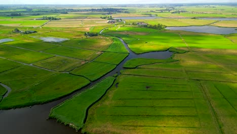 Un-Paisaje-Aéreo-De-Drones-De-Hermosos-Pólderes-Verdes-Iluminados-Por-El-Sol-En-Las-Cercanías-De-Amsterdam,-Holanda,-Con-Sombras-De-Nubes-Moviéndose-Sobre-El-Suelo