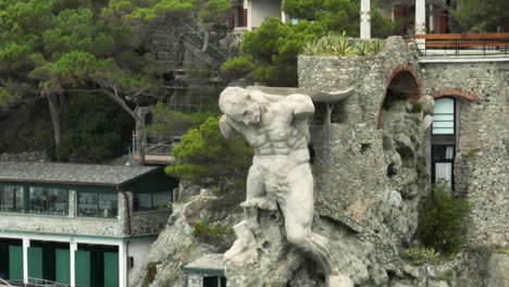 Il-Gigante-statue,-also-known-as-Monterosso-Giant,-in-Monterosso-al-Mare,-Italy-with-drone-video-pulling-back