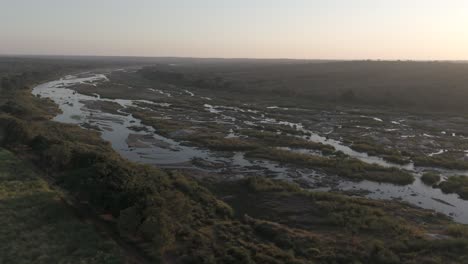 órbita-Aérea-Sobre-El-Río-Cocodrilo-Estacional-O-Efímero-Junto-A-Tierras-De-Cultivo-De-Caña-De-Azúcar-En-Sudáfrica