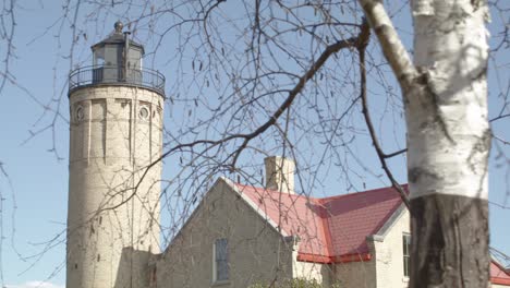 Old-Mackinac-Point-Lighthouse-in-Mackinaw-City,-Michigan-with-cinematic-video-shot-on-dolly-with-trees-in-foreground