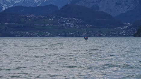 A-man-sails-on-a-lake-with-a-foil-board-and-a-wing