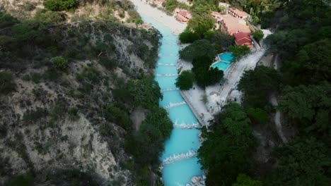 Turquoise-thermal-waters-of-the-Tolantongo-River-and-the-Mezquital-canyon-and-mountains,-Grutas-Tolantongo,-Mexico
