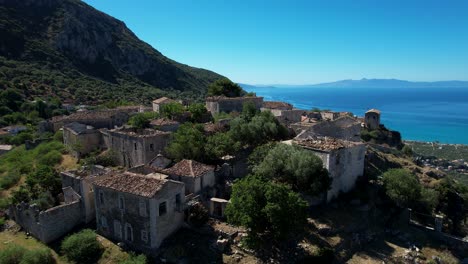 Scenic-Village-on-Rocky-Hill-of-the-Ionian-Coast-with-Traditional-Stone-Houses-Overlooking-Beautiful-Valley-of-Mediterranean-Olive-Trees-in-Albania