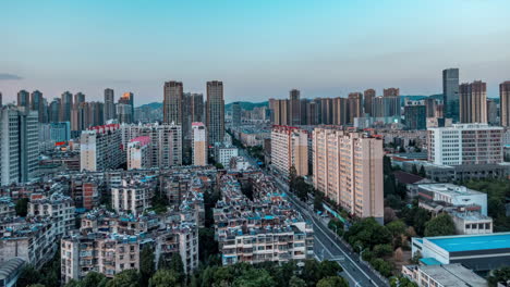 bustling-city-at-dawn-and-dusk,-Time-lapse-shot-of-vehicles-on-street-skyscrapers-landmark-buildings-in-downtown-from-day-to-night