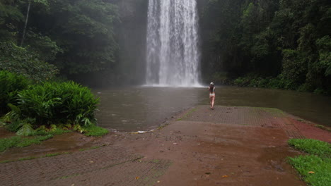 Vista-Aérea-De-Una-Joven-En-Bikini-Frente-A-Milla-Milla-Falls,-Monumento-Natural-De-Queensland,-Australia