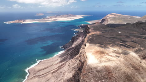 Isla-Canaria-Lanzarote-Costa-Mirador-Del-Río-Con-Vista-A-La-Isla-La-Graciosa-Y-Acantilados-Con-Este-Increíble-Océano-De-Colores